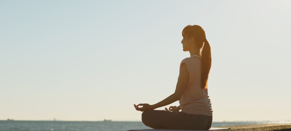 Mujer realizando mindfulness para cuidar su bienestar emocional y encontrar un momento de calma.